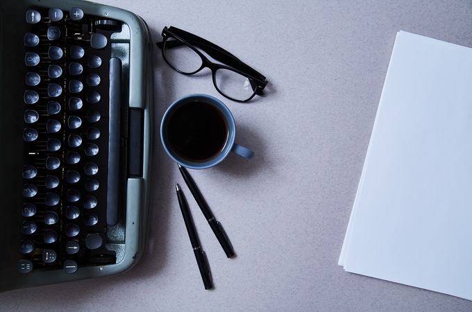 Table with type writer, glasses and cup of coffee