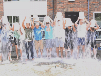 Line of people tipping buckets of water over their heads