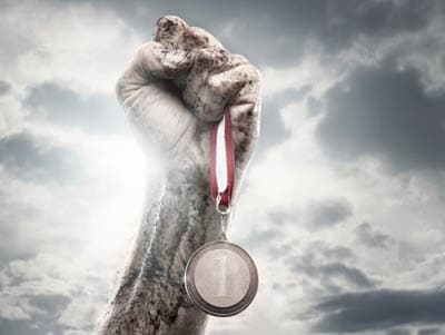 Muddy hand holding a medal