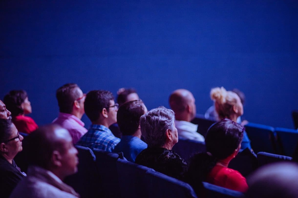 Group of people sat in seats watching presentation