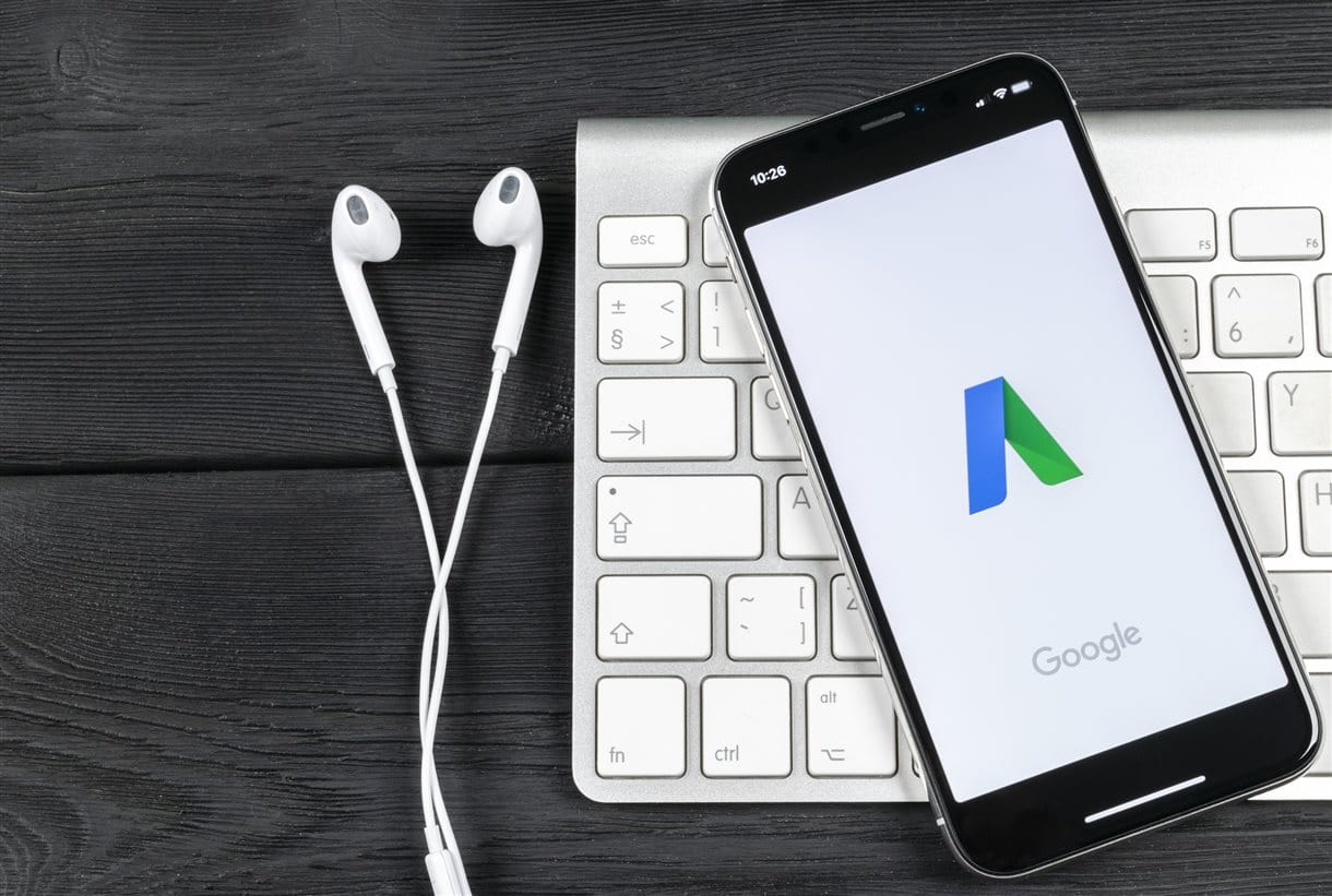 Google Ad Grant logo on phone screen plugged into headphones