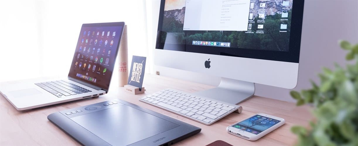 Desk with laptop, smart drawing tablet and large apple computer