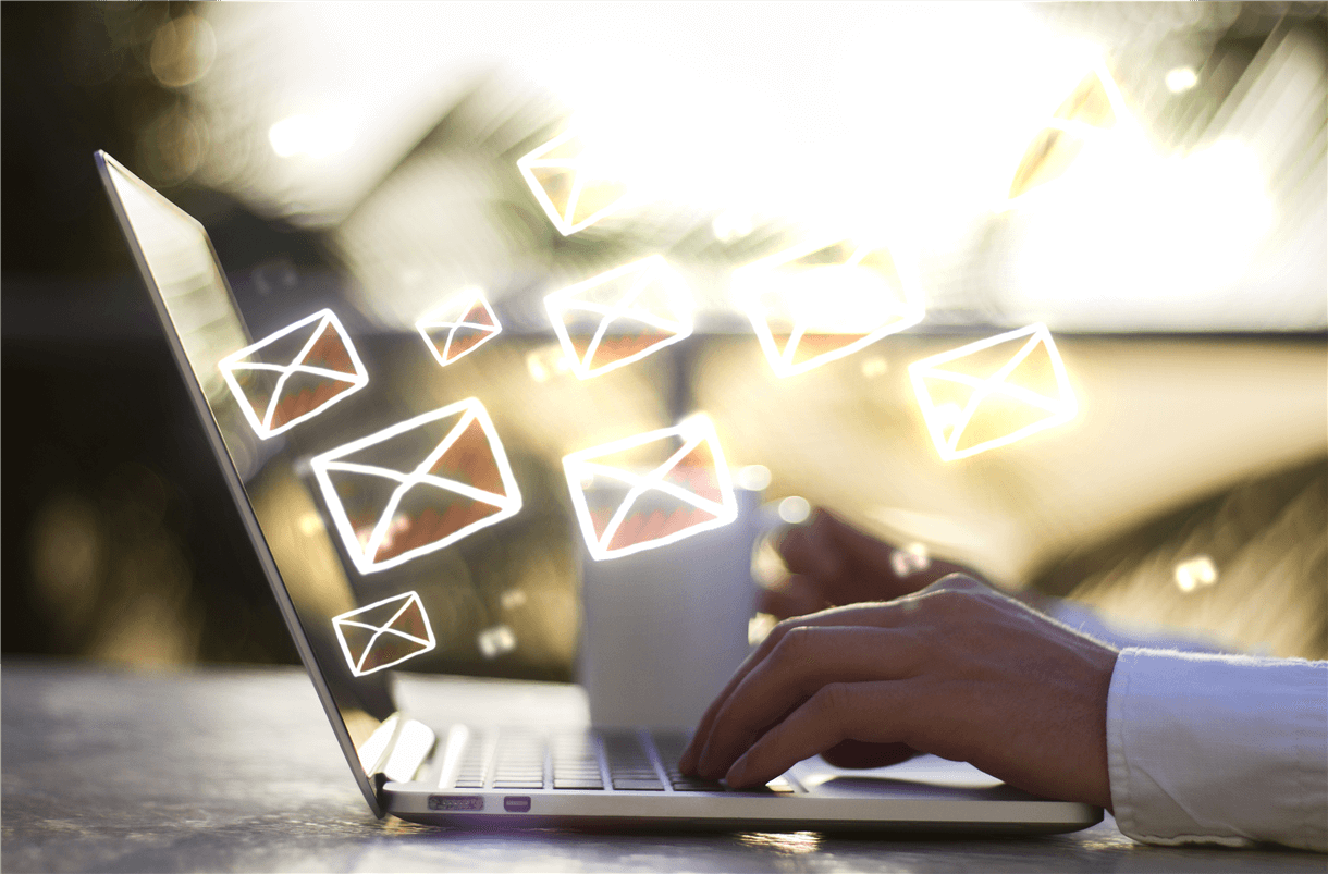 Man using laptop with email symbols