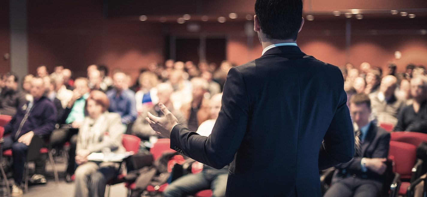 Man in suit giving speech at a conference