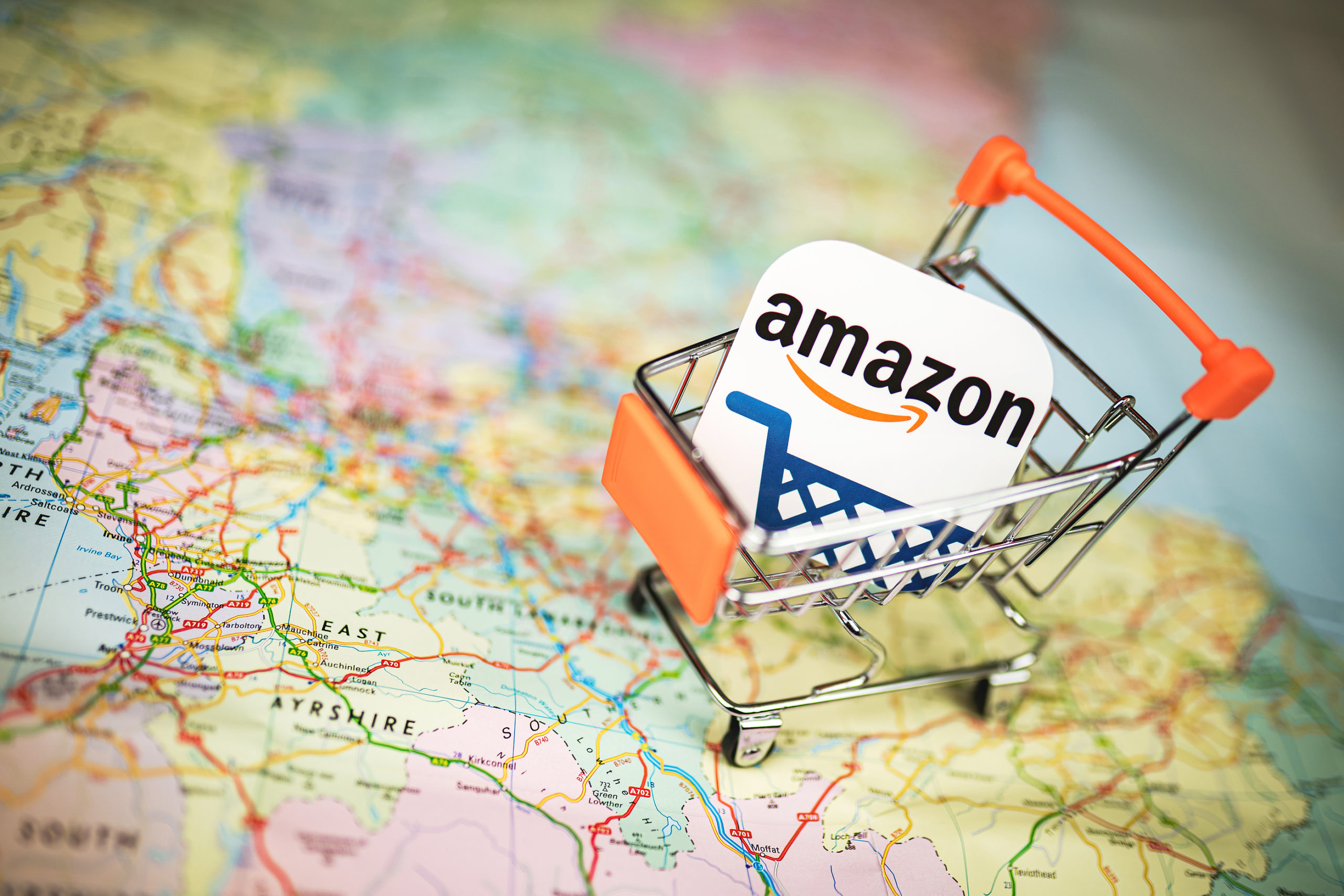 Amazon logo in shopping trolley on map of world