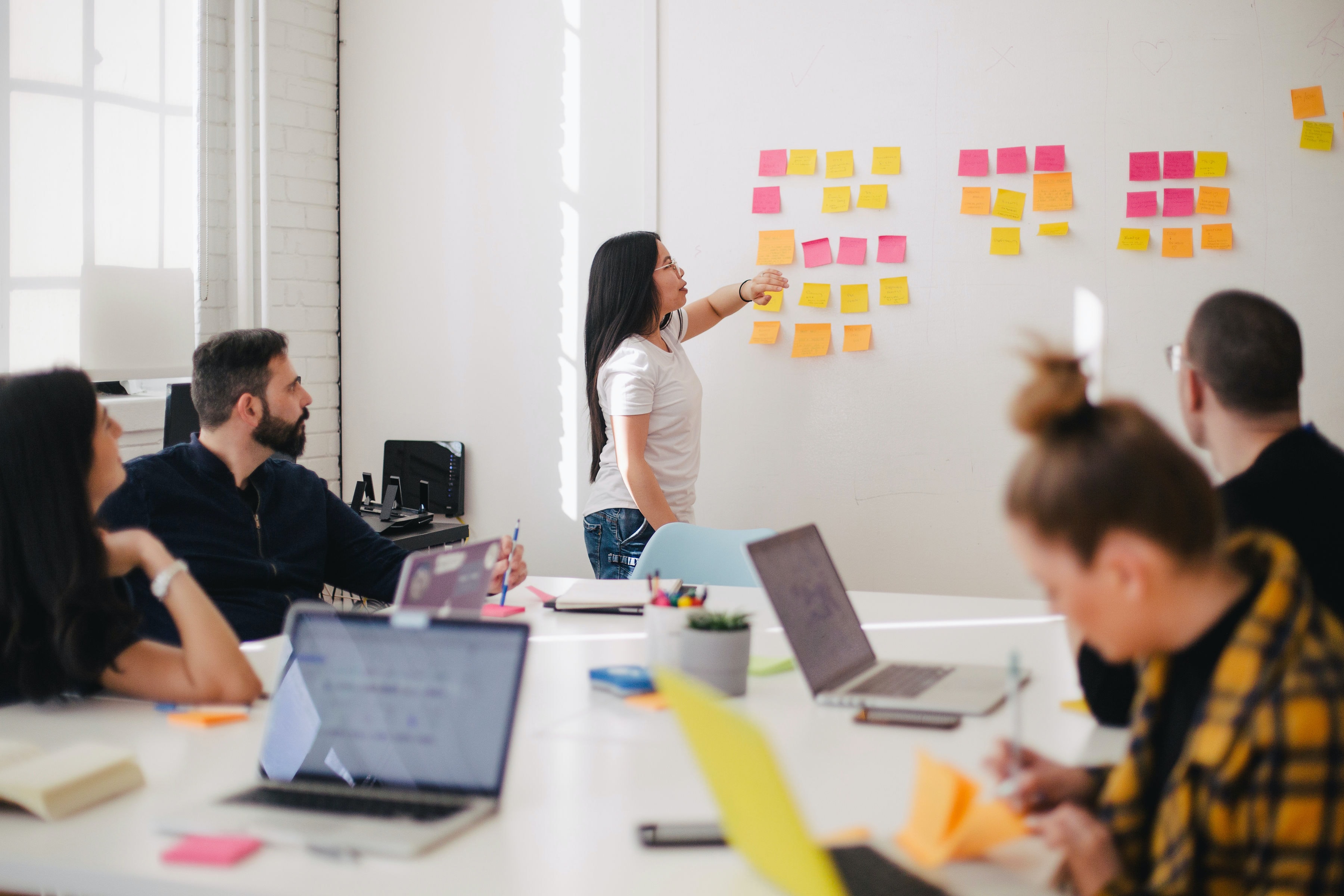 Team brainstorming with colourful post-it notes on whiteboard