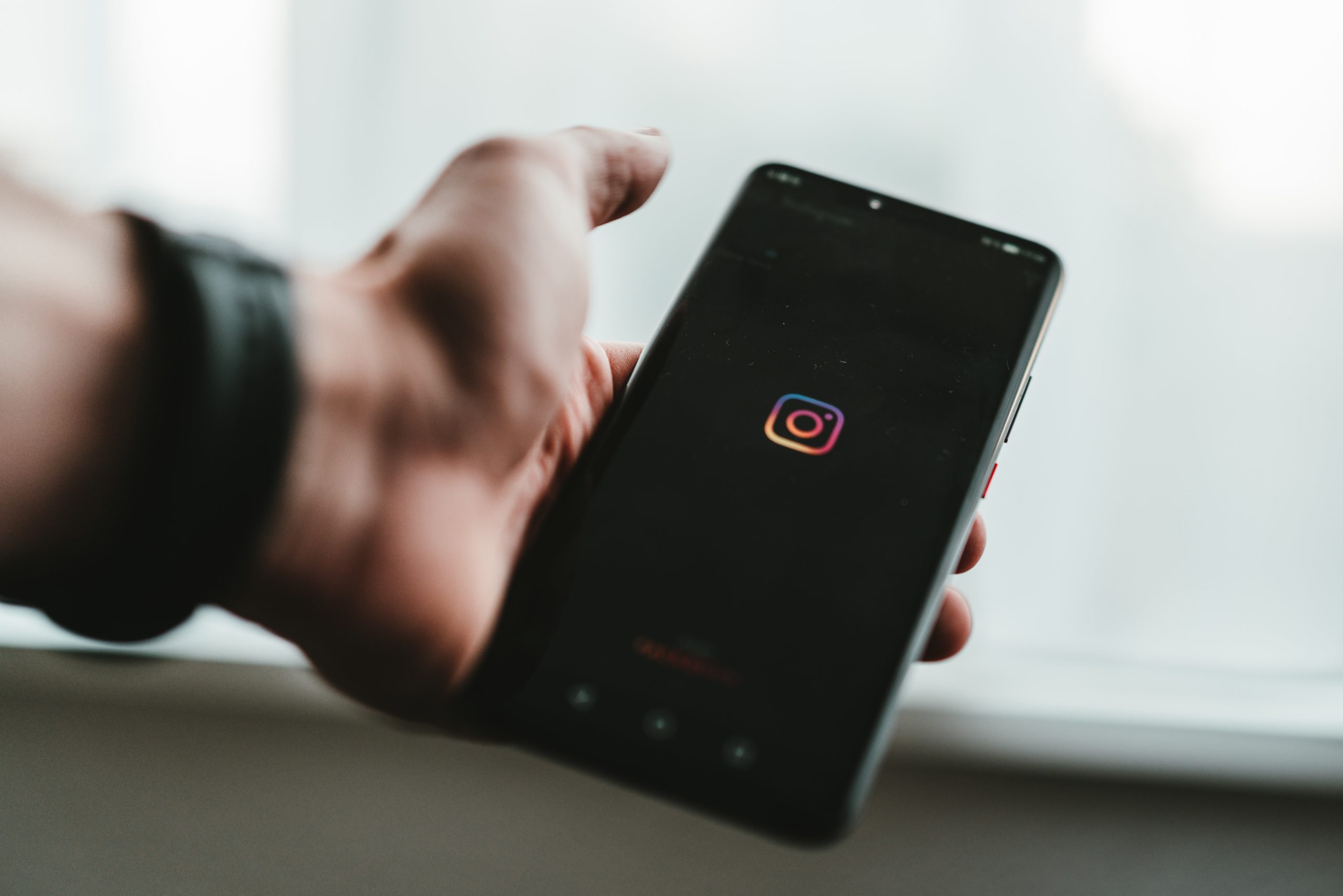 Instagram logo on black phone screen