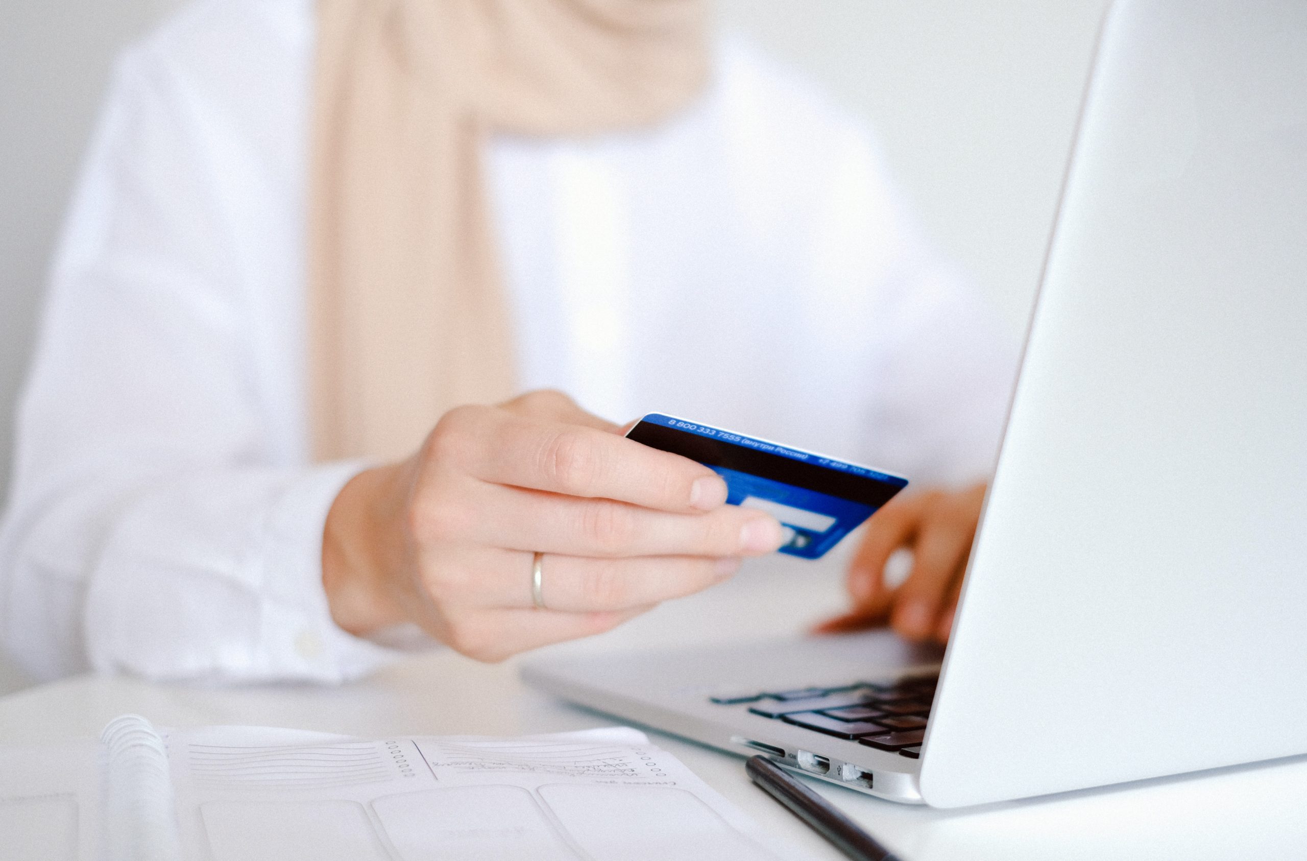 Person in white sleeved shirt holding credit card